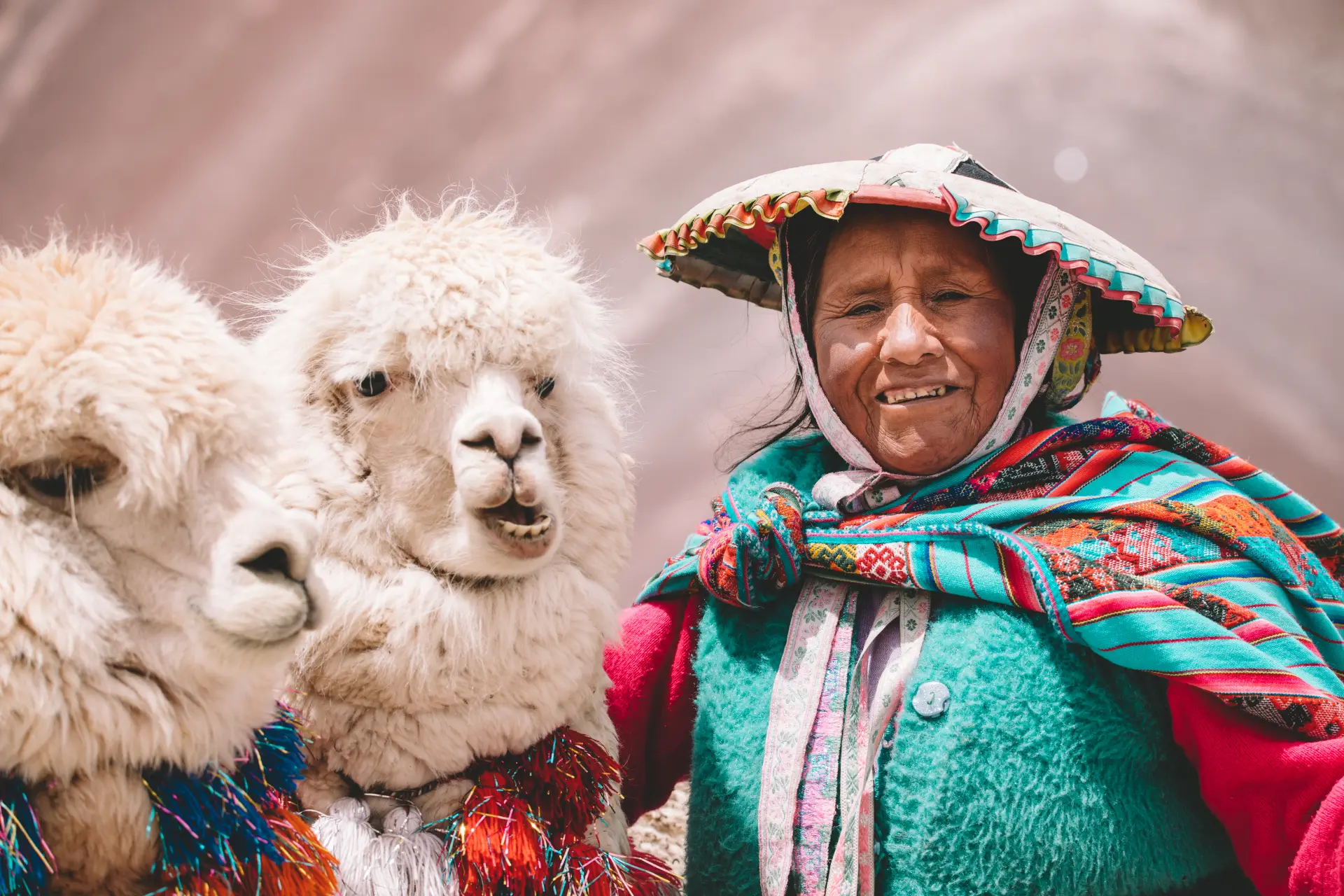 Una signora andina sorridente con i suoi alpaca a Vinicunca