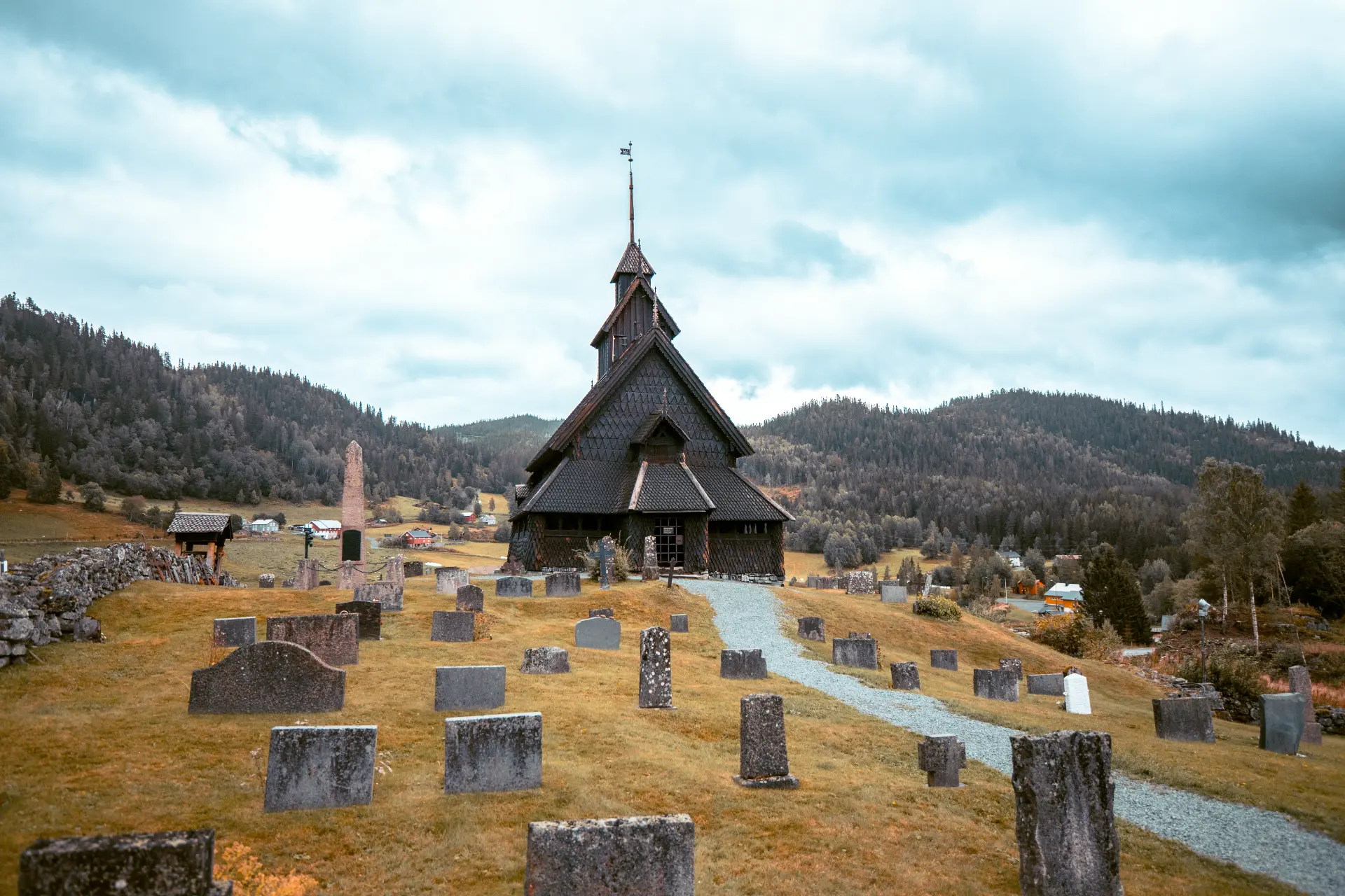 La stavkirke in legno scuro con il cimitero davanti