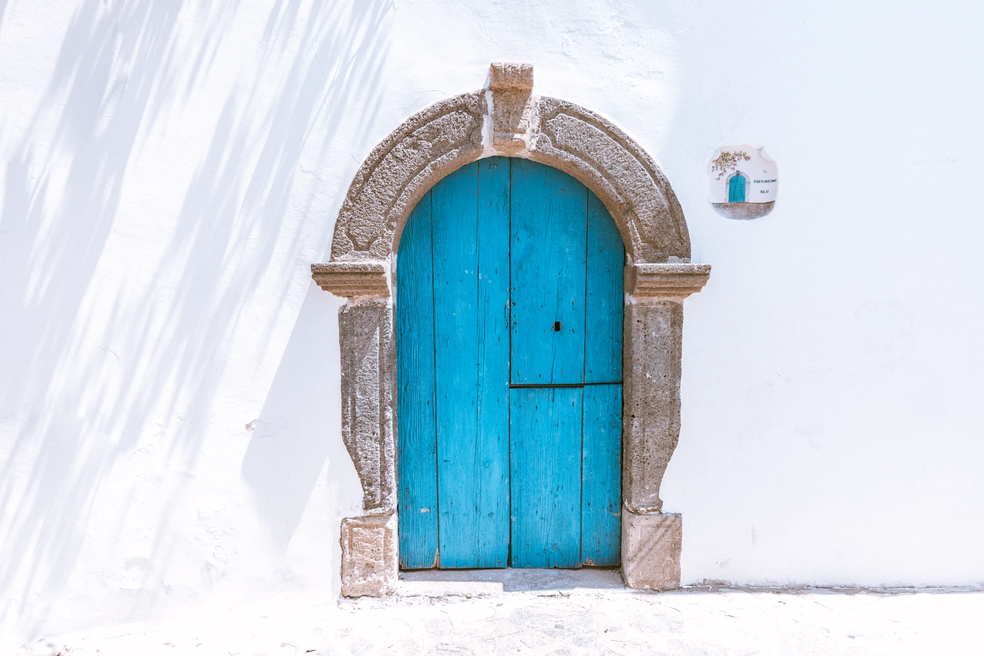 Il portoncino blu su un muro bianco eoliano