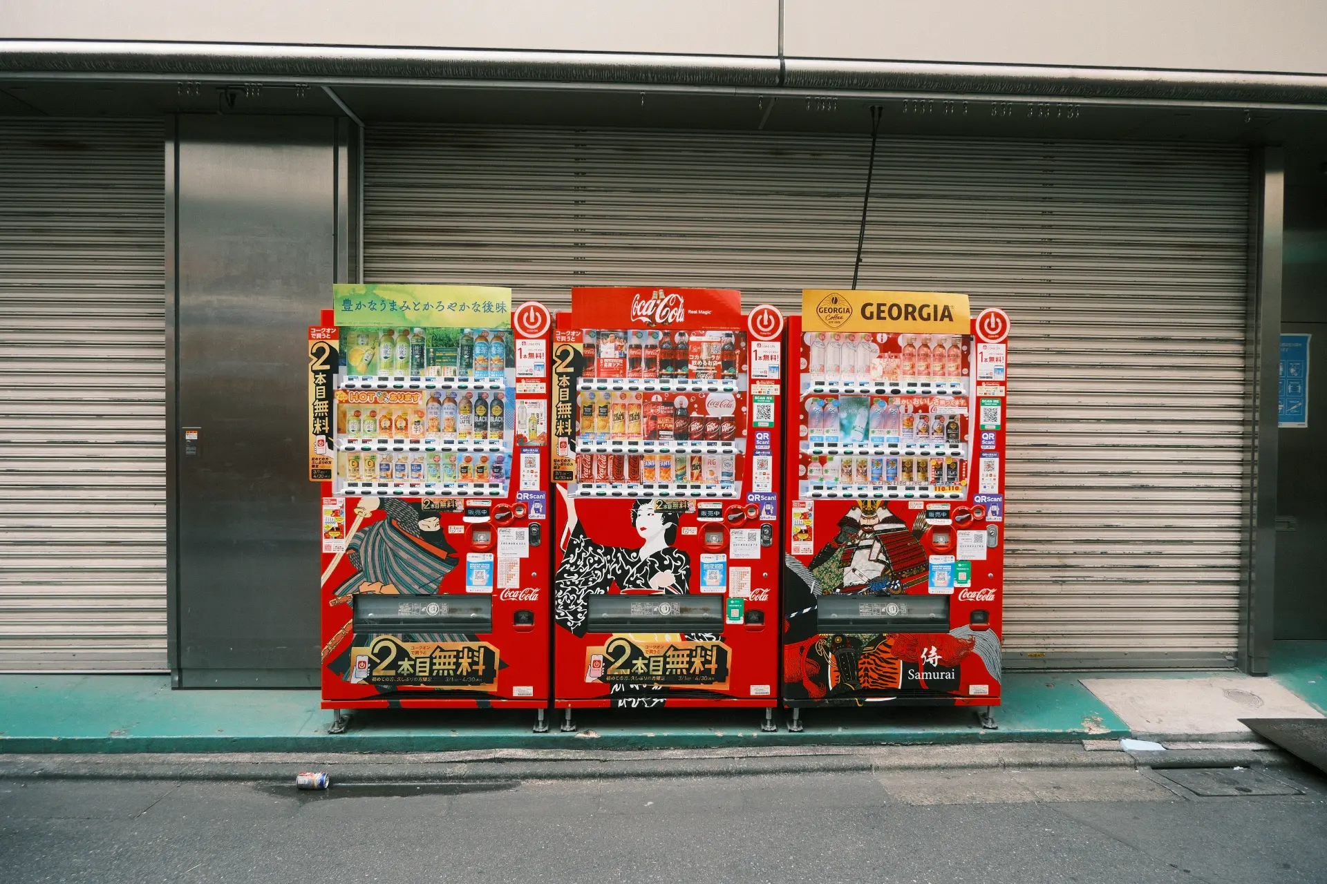 Tre distributori automatici di bevande in una via di Tokyo