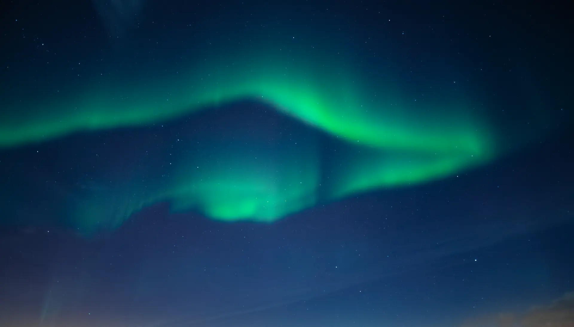 Aurora boreale verde sopra la montagna
